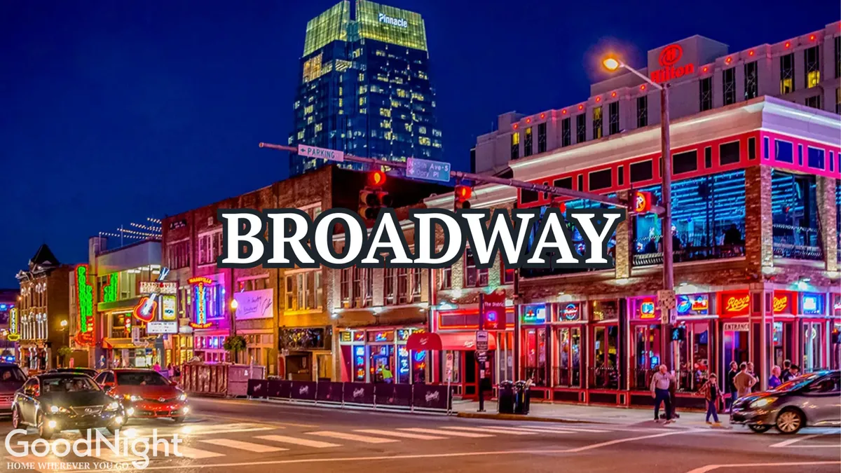 A lively street scene in West End Nashville with vibrant neon signs, bustling sidewalks, and people exploring restaurants and shops. The energy of the area is palpable, with diners, pedestrians, and cars animating the nighttime cityscape.
